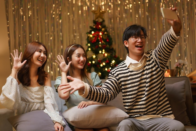 Concept de célébration du nouvel an Un groupe d'amis prend un selfie sur un smartphone ensemble lors de la fête du nouvel an