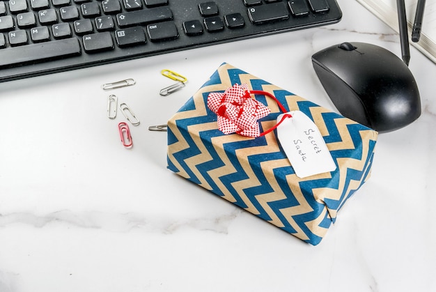 Concept de célébration de Noël de bureau, l'idée de partager des cadeaux secret Santa. Clavier, souris, ordinateur portable,