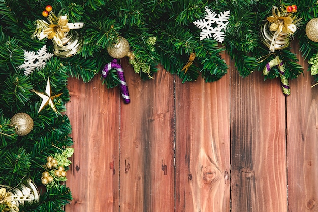 Concept de célébration de Noël et du nouvel an, des branches de pin à la frontière décorent de beaux ornements. Situé sur une planche de bois naturel. Espace vide au milieu, vue de dessus.