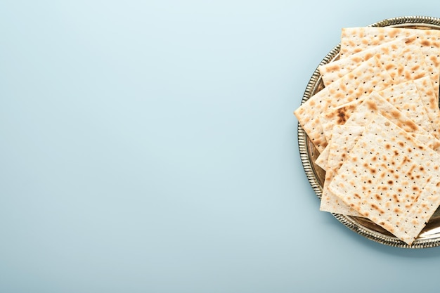 Concept de célébration de la Pâque Matzah casher rouge et noix Pain juif rituel traditionnel sur fond bleu Nourriture de la Pâque Fête juive de Pessa'h