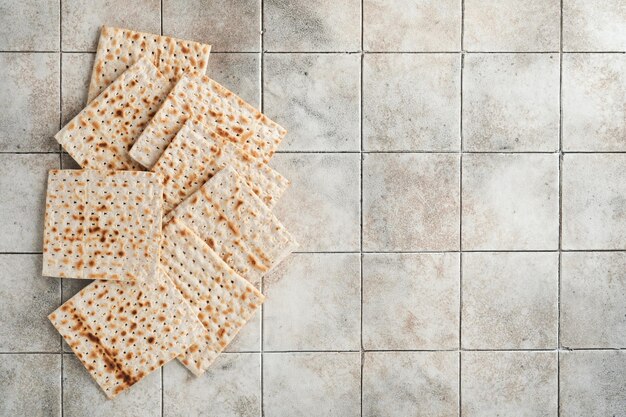 Concept de célébration de la Pâque Matzah rouge noix casher Pain juif rituel traditionnel sur le vieux fond de table de comptoir de tuiles grises Nourriture de la Pâque Fête juive de Pessa'h