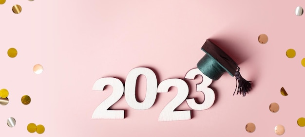 Concept de la classe 2023 Numéro en bois 2023 avec capuchon gradué sur fond coloré