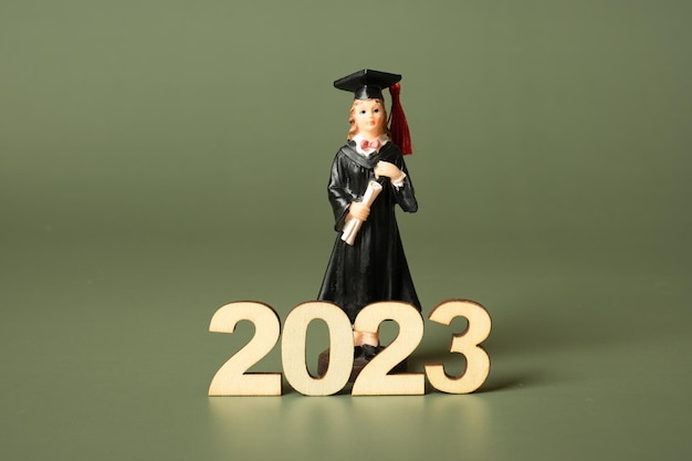 Concept de classe de 2023 Numéro en bois 2023 avec statuette diplômée sur fond de couleur