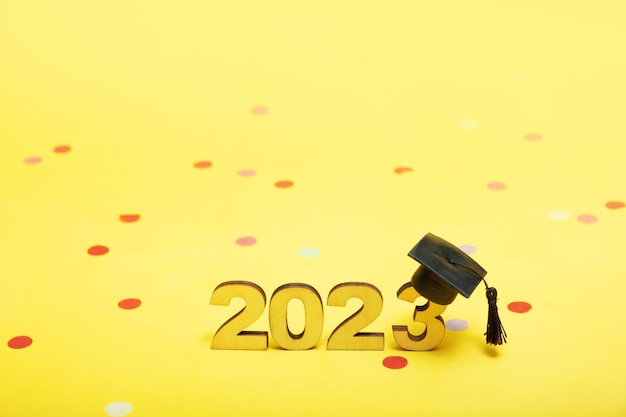 Concept de classe de 2023 Numéros 2023 avec capuchon noir gradué sur fond jaune