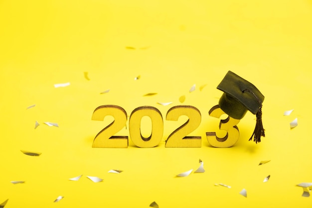 Concept de classe de 2023 Numéros 2023 avec capuchon noir gradué sur fond jaune