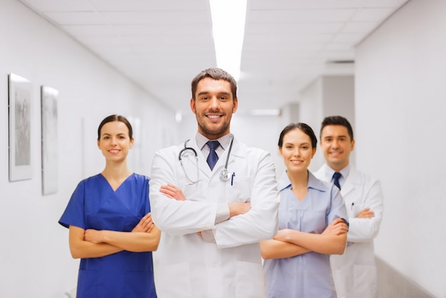 concept de clinique, de profession, de personnes, de soins de santé et de médecine - groupe heureux de médecins ou de médecins dans le couloir de l'hôpital