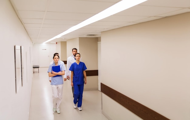 concept de clinique, de profession, de personnes, de soins de santé et de médecine - groupe de médecins ou de médecins marchant le long du couloir de l'hôpital