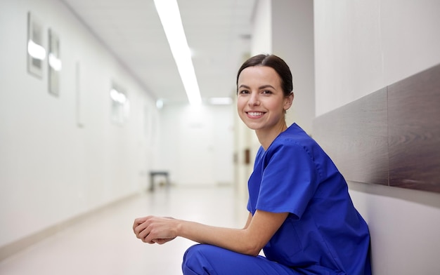 concept de clinique, de profession, de personnes, de soins de santé et de médecine - infirmière souriante dans le couloir de l'hôpital