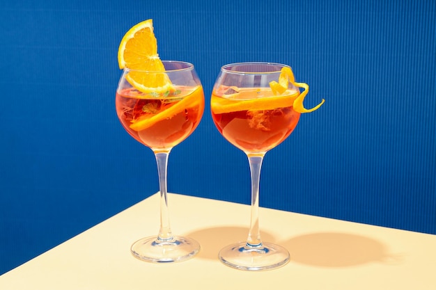 Concept de cocktail d'été Aperol Spritz sur table beige sur fond bleu