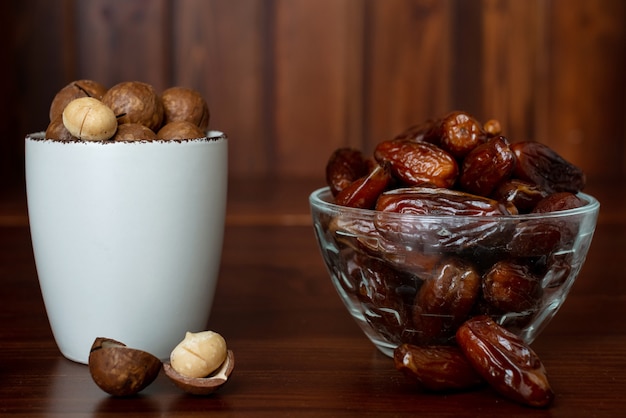 Concept de collation saine. Mise au point sélective. Noix de macadamia et fruits de palmier dattier. Gros plan de fruits secs et de noix