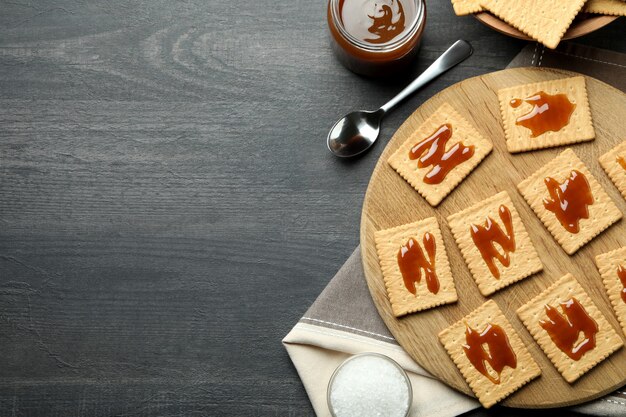 Concept de collation savoureuse avec des cookies au caramel sur une table en bois sombre