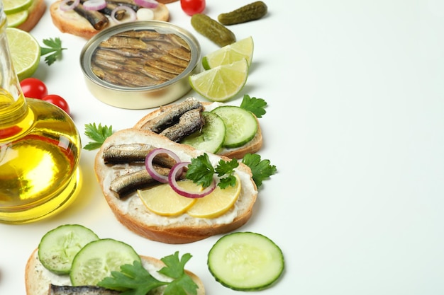 Concept de collation savoureuse avec des sandwichs aux sprats sur fond blanc