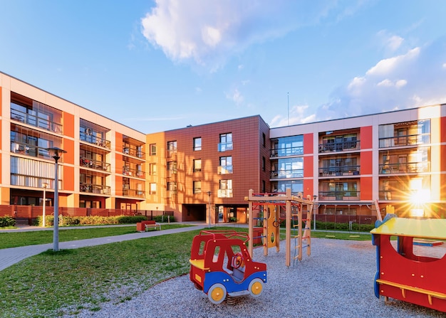 Concept complexe d'immeubles d'appartements et de maisons. Rue avec aire de jeux pour enfants. Avec la lumière du soleil