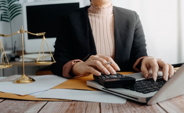 Photo concept de comptabilité d'entreprise homme d'affaires à l'aide d'une calculatrice avec budget d'ordinateur portable et papier de prêt au bureau