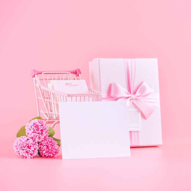 Concept de conception de cadeau de vacances de la fête des mères bouquet de fleurs d'oeillets roses avec sac de panier emballé boîte isolé sur l'espace de copie de fond rose clair