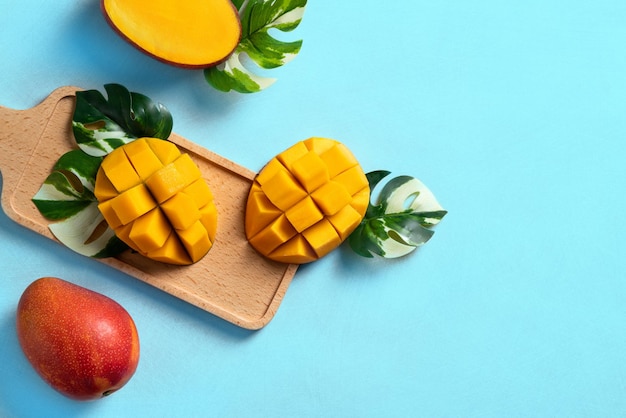 Concept de conception de fond de mangue Vue de dessus Mangue fraîche coupée en dés sur table bleue