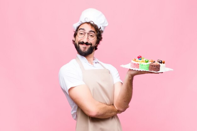 Concept de confiserie jeune boulanger fou contre mur rose