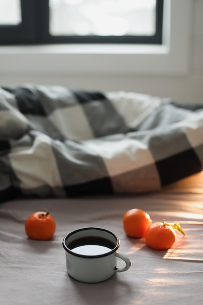Concept confortable d'hiver Tasse avec café et mandarines sur le lit Espace de copie Vue de dessus à plat