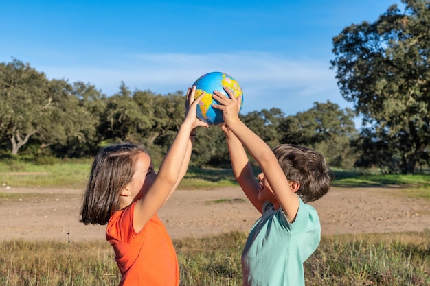 Concept de conservation de la terre 2 Les enfants étreignent le globe terrestre avec leurs mains