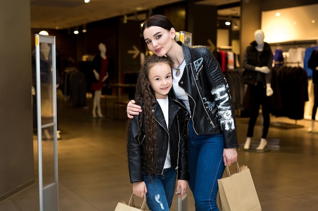 Concept de consommation et de personnes de vente - heureuse mère et enfant avec des sacs à provisions