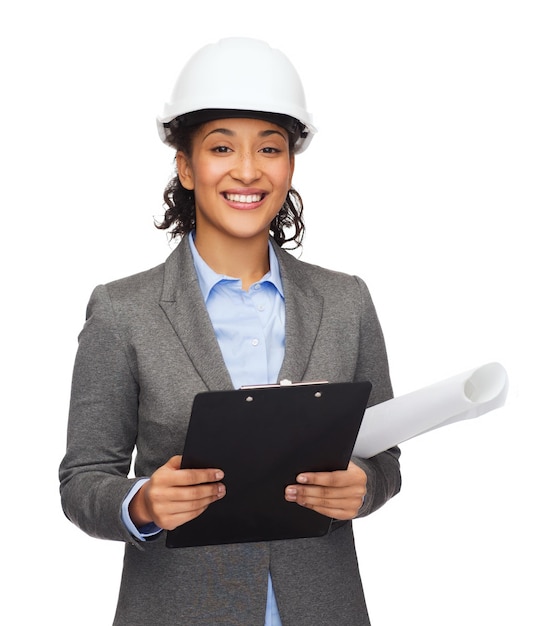 concept de construction, de développement, de construction et d'architecture - femme d'affaires souriante en casque blanc avec presse-papiers et plan