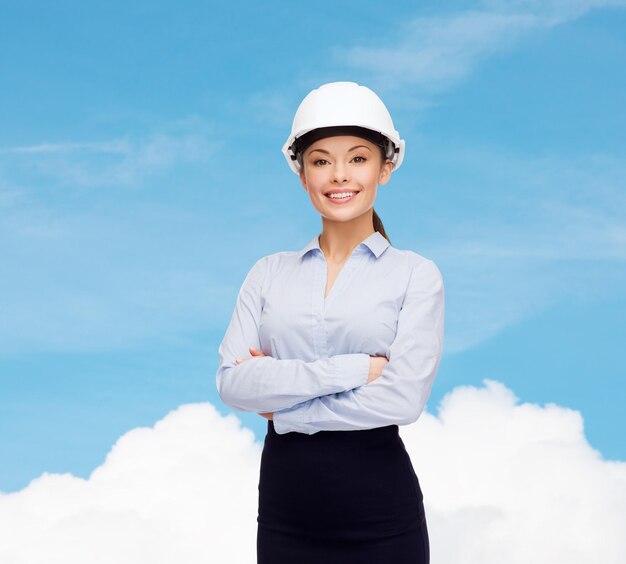 concept de construction, de développement, de construction et d'architecture - sympathique jeune femme d'affaires souriante en casque blanc