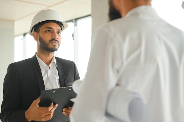 Photo concept de construction d'ingénieur et d'architecte multiracial travaillant sur un chantier de construction avec impression bleue