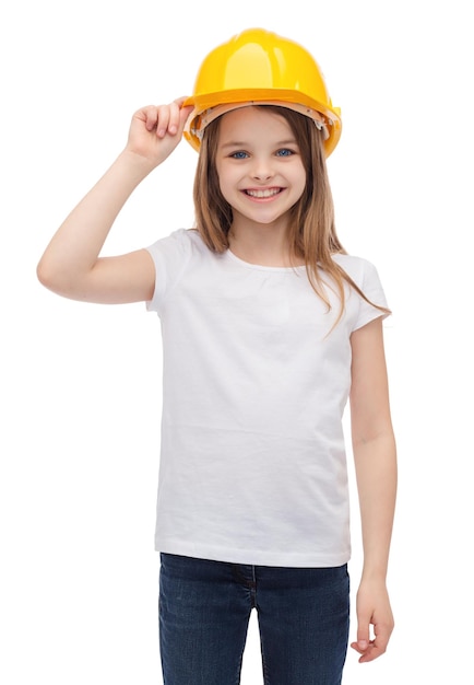 concept de construction et de personnes - petite fille souriante dans un casque de protection