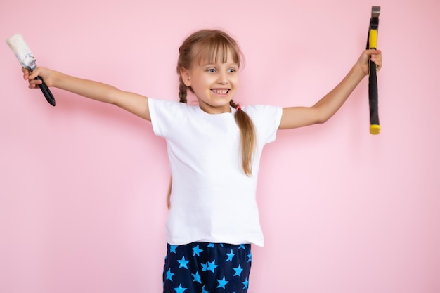 concept de construction et de personnes - petite fille souriante avec un marteau