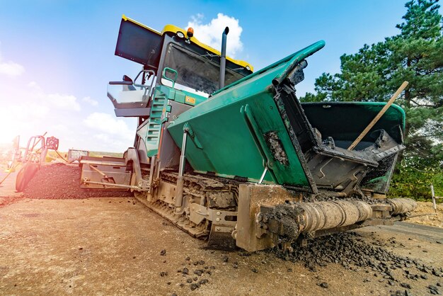 Concept de construction de route de chaussée d'asphalte frais de machinerie lourde de finisseur sur chenilles