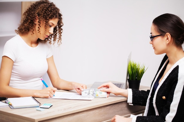 Photo concept de corruption, une femme verse un pot-de-vin à un employé de l'entreprise pour la signature d'un contrat.