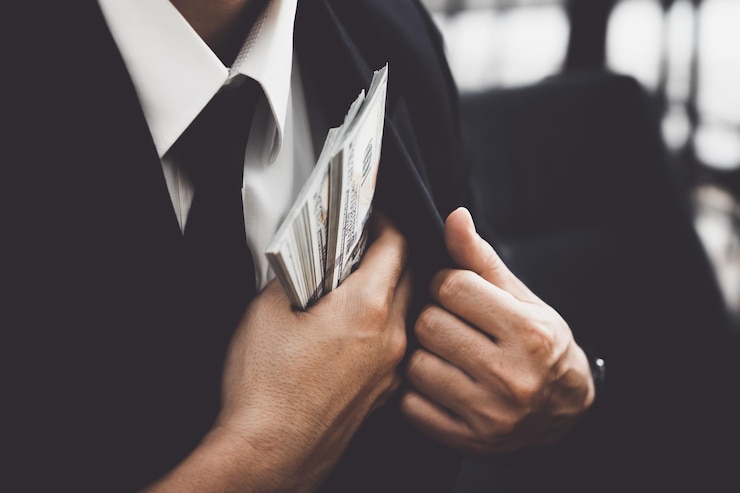 Photo le concept de corruption la loi entre les mains des bureaucrates mettez une grosse somme d'argent dans votre poche après avoir signé des documents importants au profit des entreprises privées