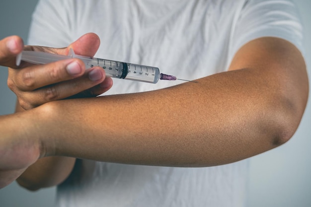 Photo concept de coude de tennis l'homme s'injecte un médicament pour traiter sur son avant-bras connaissance de la santé gros plan moyen