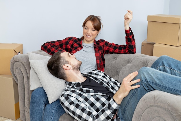 Concept de couple en déménagement homme et femme avec des boîtes dans l'appartement