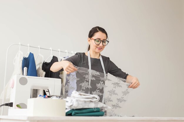 Concept de couturière, tailleur, mode et salle d'exposition - Portrait d'une couturière talentueuse travaillant avec du textile pour coudre des vêtements.