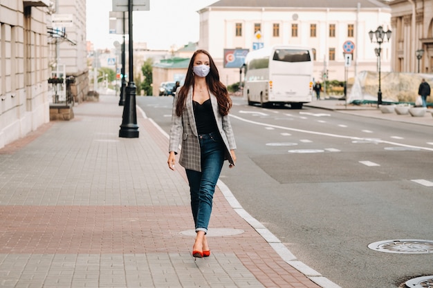 Concept de Covid-19 et de pollution atmosphérique pm2.5. Pandémie, portrait d'une jeune femme portant un masque de protection dans la rue. Concept santé et sécurité.