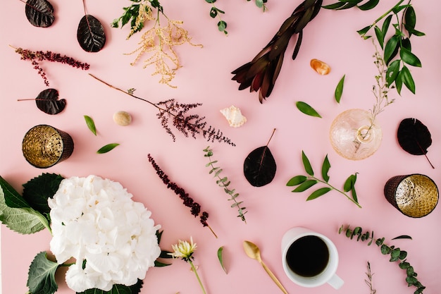 Concept créatif décoré et disposé à plat avec hortensia, coquillages, café, cuillère en or, branches sur rose