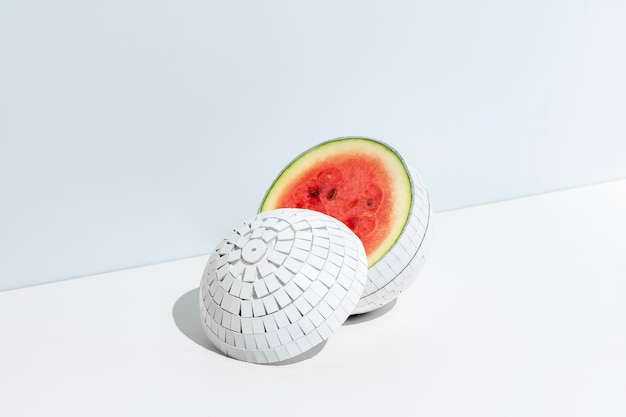 Concept créatif de fruits d'été Boule de disco blanche en miroir avec une pastèque à l'intérieur sur fond blanc