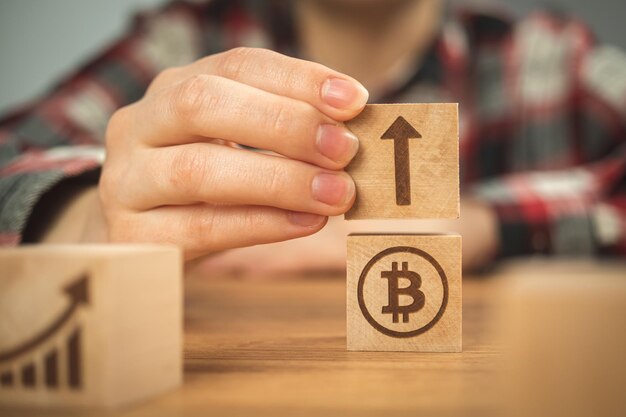 Concept de croissance bitcoin flèche vers le haut graphique BTC des symboles de croissance sur un cube en bois dans les mains vue rapprochée photo