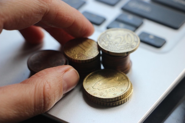 Concept de croissance financière et commerciale Close up Of Businessman Hand Count et Put Money Coins To Stack Of Coins on computer keyboard