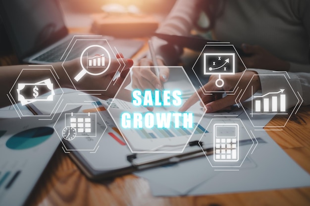 Concept de croissance des ventes Équipe d'affaires analysant les graphiques et les graphes des revenus sur le bureau avec l'icône de croissance des sales sur l'écran virtuel