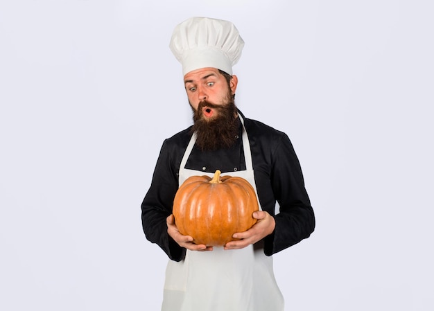 Concept de cuisine d'automne homme en tablier blanc présentant une citrouille pour l'action de grâce culinaire saisonnière