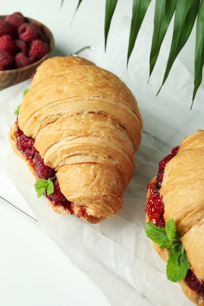 Concept de cuisine délicieuse avec des croissants à la confiture de framboises sur fond blanc