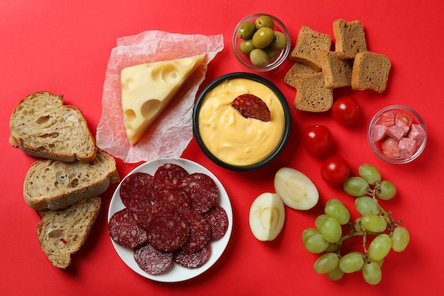 Concept de cuisine délicieuse avec fondue sur fond rouge