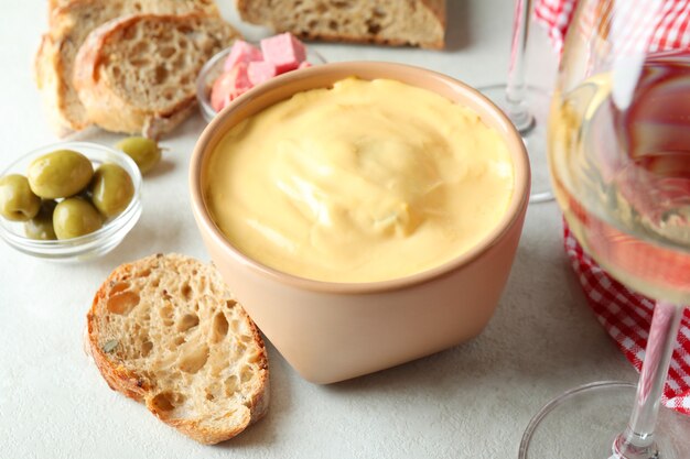 Concept de cuisine délicieuse avec fondue sur une table texturée blanche