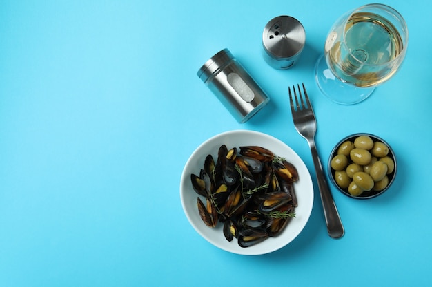 Concept de cuisine délicieuse avec des moules sur fond bleu