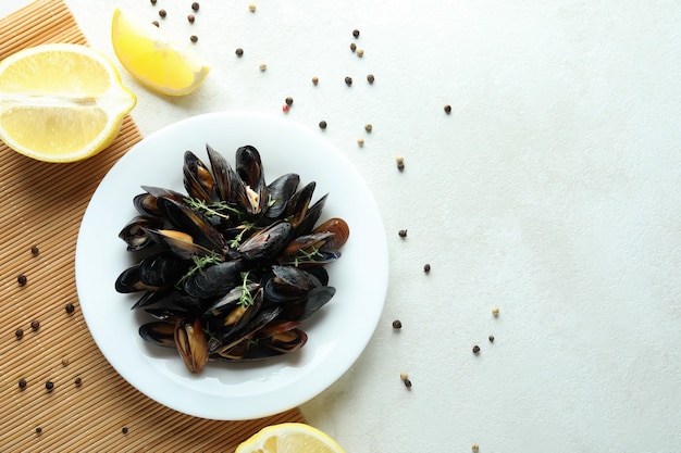 Concept de cuisine délicieuse avec des moules sur une table texturée blanche