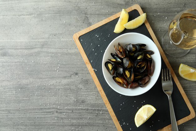 Concept de cuisine délicieuse avec des moules sur une table texturée grise