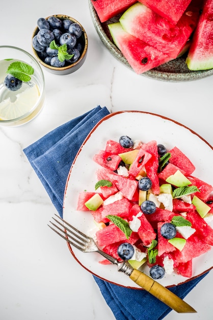 Concept de cuisine estivale, salade de melon d'eau froide avec fromage feta, myrtille, avocat et menthe