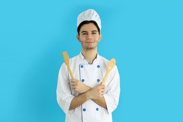 Concept de cuisine jeune chef masculin sur fond bleu